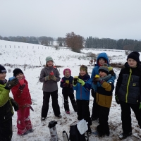 Kinder machen Pause im Schnee mit Heißgetränken